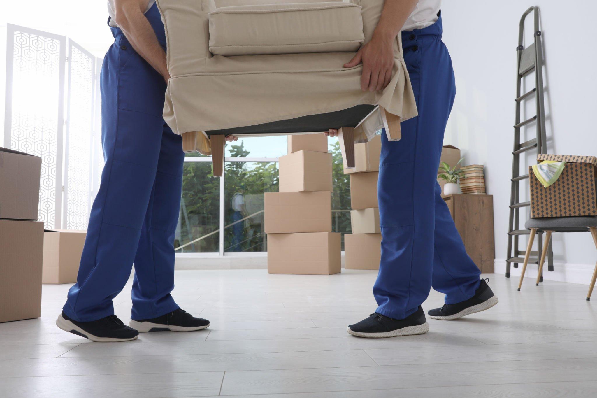 Professional movers loading furniture into moving truck