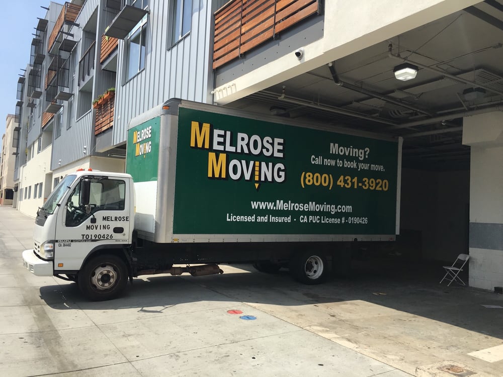 Professional movers loading truck in Pomona residential neighborhood